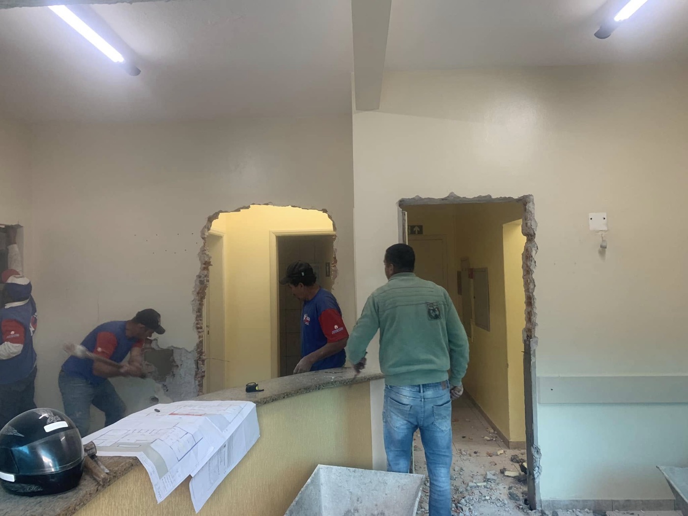 Equipe realizando reforma comercial com plantas na bancada